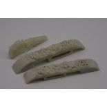 Two carved jade belt buckles, largest 17cm long; together with another carved celadon jade belt