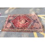 A Persian rug, having central diamond medallion with floral and geometric borders, 176 x 130cm.