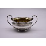 A George III silver gilt lined twin handled sugar basin, by W Elliot, London 1818, 10.5cm high,