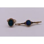 An oval opal gold ring, stamped 9ct; together with a similar bar brooch, 5cm, (both opals