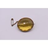 A large oval citrine brooch, in an unmarked yellow metal mount, 3.5 x 3cm.