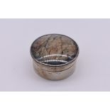 A silver and lapis lazuli pill box, makers mark indistinct, Birmingham 1923, 4cm diameter.