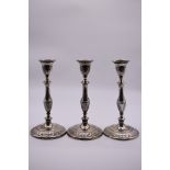 A set of three Adam style silver candlesticks, by Harrison Brothers & Howson, Sheffield 1924, 26cm