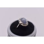 A cabochon cat's eye moonstone and diamond white gold ring, having unmarked mount.