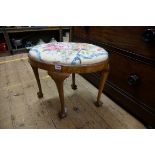 A 1930s walnut oval stool, with tapestry slip in seat and ball and claw feet, 59cm wide.