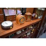 A collection of four various clocks and timepieces, to include a 1930s walnut dome top example by
