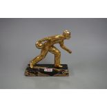 A gilt metal figure of a bowler, on marble base, 18cm high.