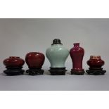 An interesting group of small Chinese monochrome vases, largest 9.5cm high, each on fitted wood