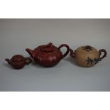 Three Chinese yixing teapots and covers, mark to base of each, largest 7.5cm high. (3)