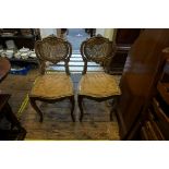 A pair of Louis XV style carved gilt wood and cane salon chairs.