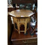 A Moorish brass inlaid octagonal folding occasional table, 40cm wide.