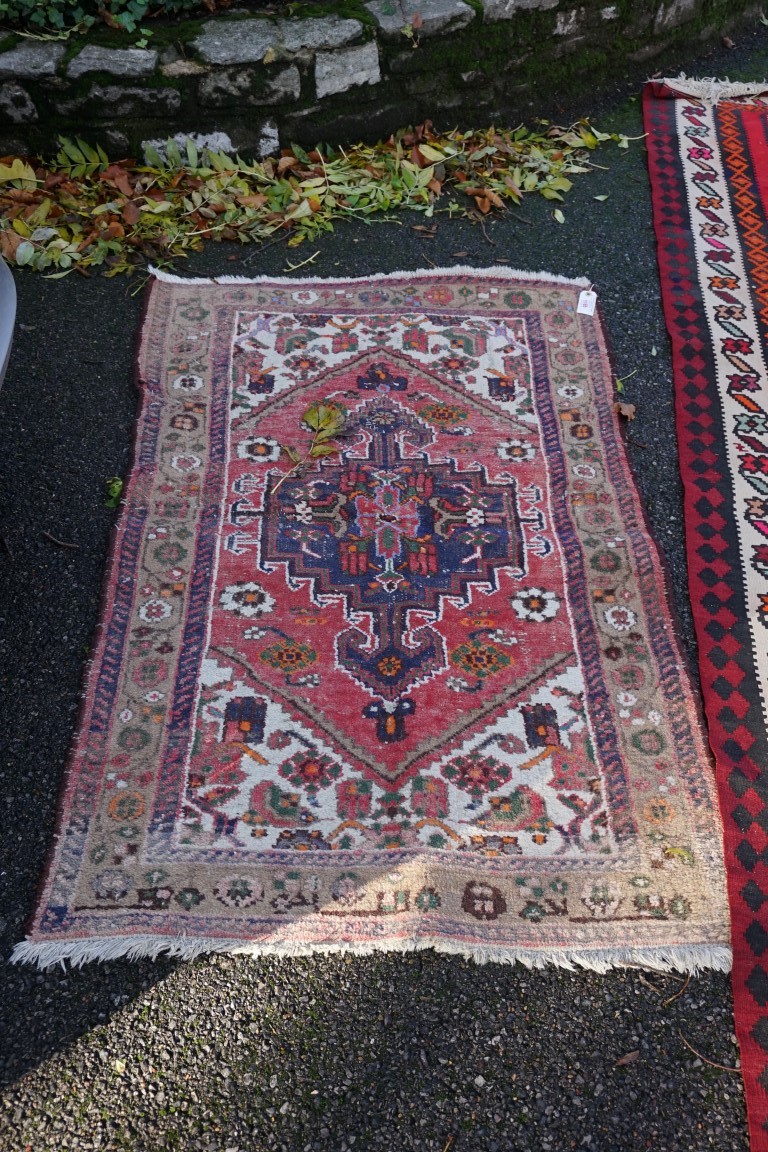 An old Persian rug, having central medallion with floral borders, 148 x 110cm.