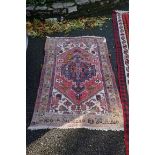 An old Persian rug, having central medallion with floral borders, 148 x 110cm.