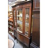 An Edwardian mahogany and inlaid bowfront display cabinet, 114cm wide.
