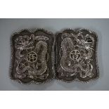 A Chinese silver belt buckle, by Kwan Wo, relief decorated with dragons, each half 6.5 x 5cm, 63g.