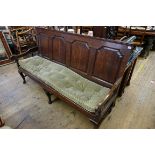 (THH) An 18th century oak settle, with fielded four panel back above webbed seat flanked by open