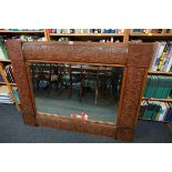 A large Arts and Crafts carved walnut framed rectangular wall mirror, 105 x 136.5cm.