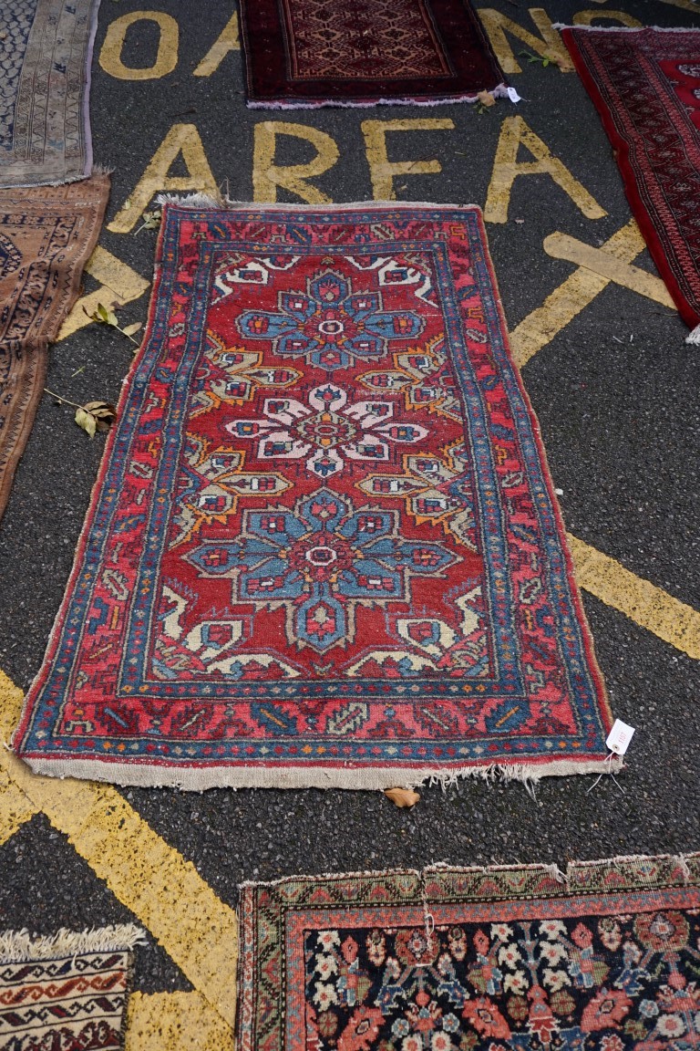 A Persian rug, having three floral medallions with geometric borders, 180 x 104cm.