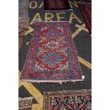 A Persian rug, having three floral medallions with geometric borders, 180 x 104cm.