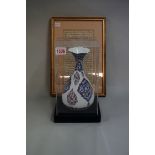 A Persian enamel baluster vase, 22.5cm high; together with an Islamic manuscript page, 22 x 12.