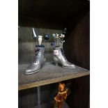 A pair of novelty plated metal boot pin cushions, with various pins, the boots 9.5cm high.