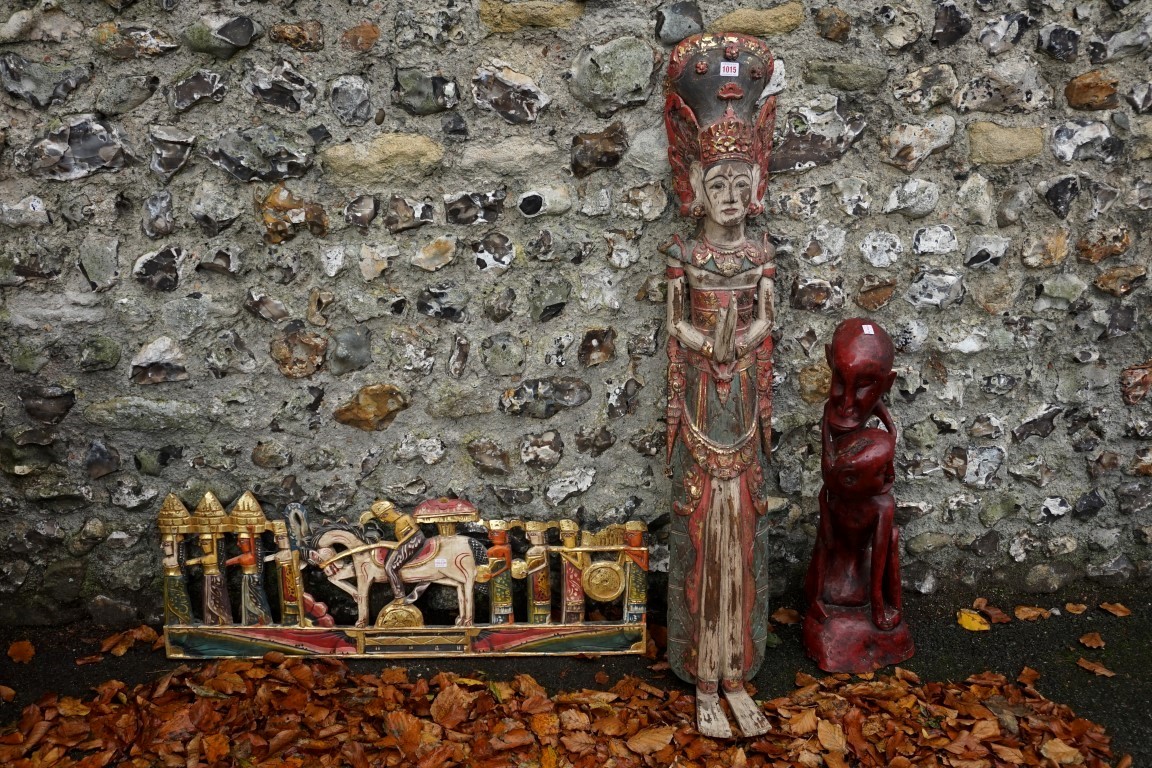 A red stained tribal figure; together with another figure; and a carved figure group. This lot can