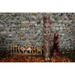 A red stained tribal figure; together with another figure; and a carved figure group. This lot can