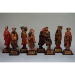 A set of eight Chinese carved and stained wood figures, each on inscribed wood base, total height