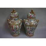 A large pair of Chinese Canton famille rose twin handled vases and covers, 19th century, with lion