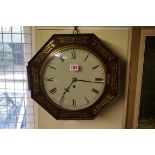 A Regency rosewood and brass inlaid octagonal wall clock, with 10in painted circular dial and single