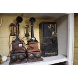 Two vintage candlestick telephones, and wall boxes; together with a vintage telephone kiosk cash