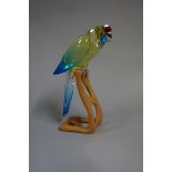 A Swarovski Green Rosella Jonquil Parrot, 901601, 21cm high, on wood stand.