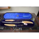 A cased ivory handled three piece carving set.