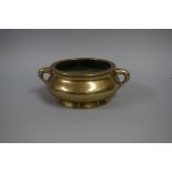 A Chinese polished bronze twin handled censer, Xuande six character mark to base, 17cm wide, 861g.