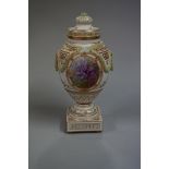 A KPM porcelain urn and cover, painted with floral panels, 24.5cm high.