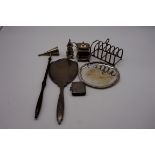 A small group of silver items, to include: a six section toast rack; a candle snuffer; a vesta case;