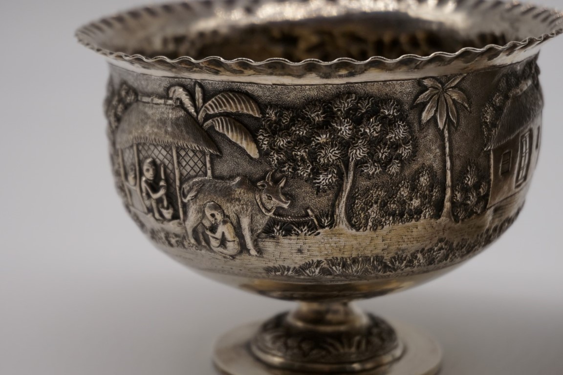 A pair of Indian white metal pedestal bowls, decorated village scenes, 8.5cm high. - Image 3 of 3