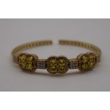 An Italian natural yellow sapphire and pave set diamond gold bangle, stamped 'Italy 750'.