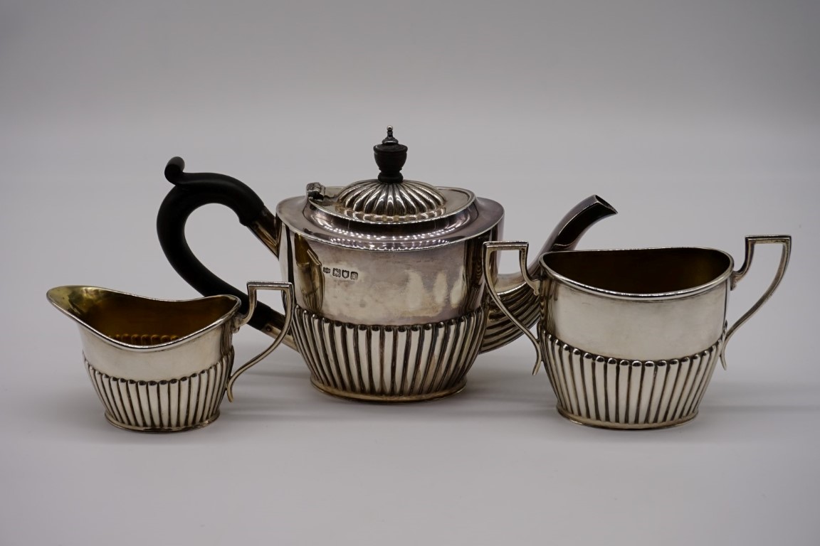 An Edwardian silver three piece bachelor's tea set, by Robert Pringle & Sons, London 1903/4, 11cm