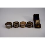 A cased silver napkin ring, by Martin, Hall & Co, Sheffield 1910; together with four other examples,
