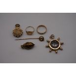 A small group of yellow metal items, comprising: two open lockets; two rings; a stick pin; and a