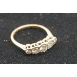 A five stone diamond gold ring, stamped 18ct and Plat, having illusion set stones of approximately