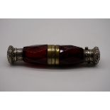A cranberry cut glass double ended scent bottle, having embossed metal mounts, 12.5cm.