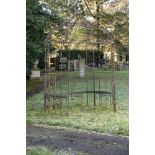 Gazebo/pergola: A wrought iron gazebo, 20th century, incorporating benches, 290cm high by 205cm