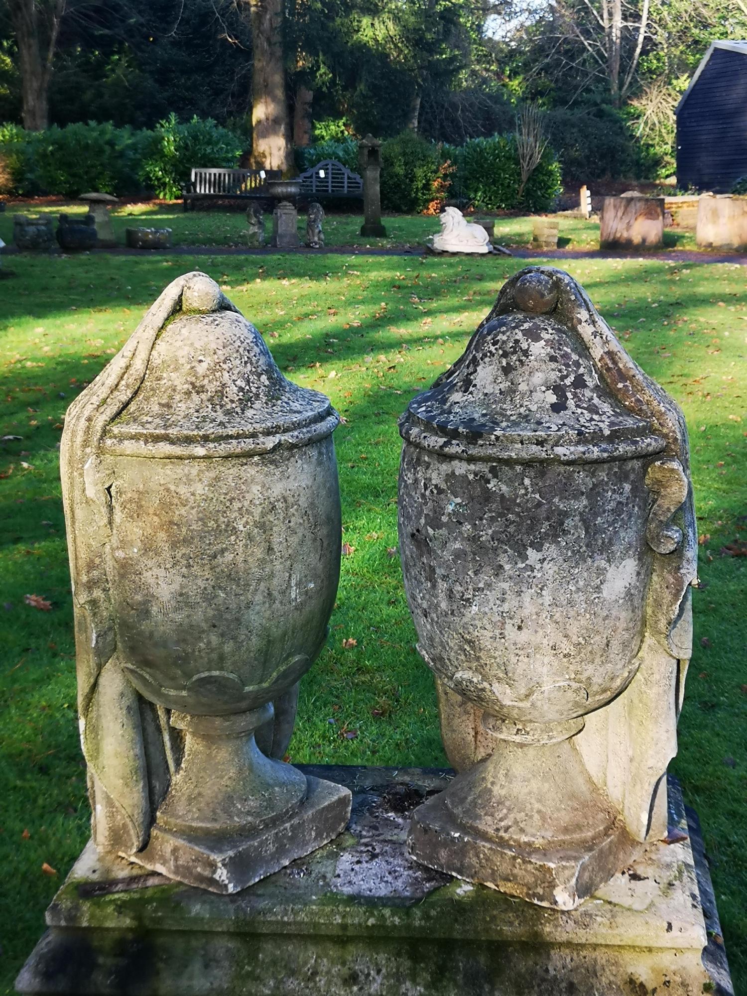 Finials: A pair of carved limestone draped urns, 19th century, 68cm high