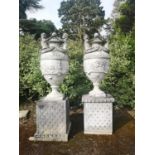 Finials: A pair of substantial composition stone lidded urns on pedestals, late 20th century,