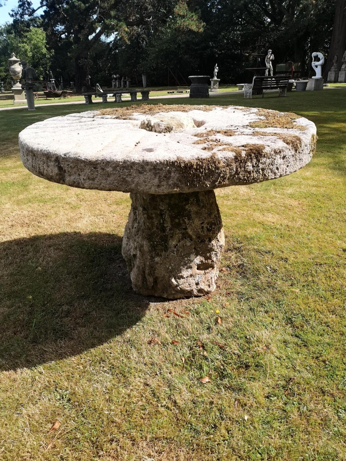 Garden Tables/Furniture: A carved stone table with millstone top on staddlestone base, 122cm