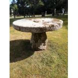Garden Tables/Furniture: A carved stone table with millstone top on staddlestone base, 122cm