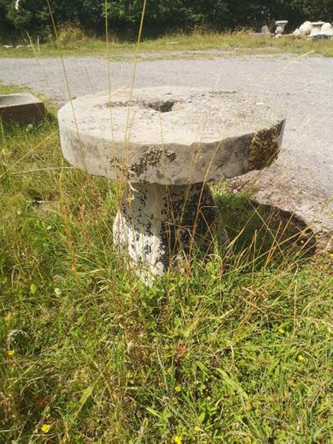 Garden Tables/Furniture: A stone table with a millstone top on staddlestone base, 79cm diameterThe