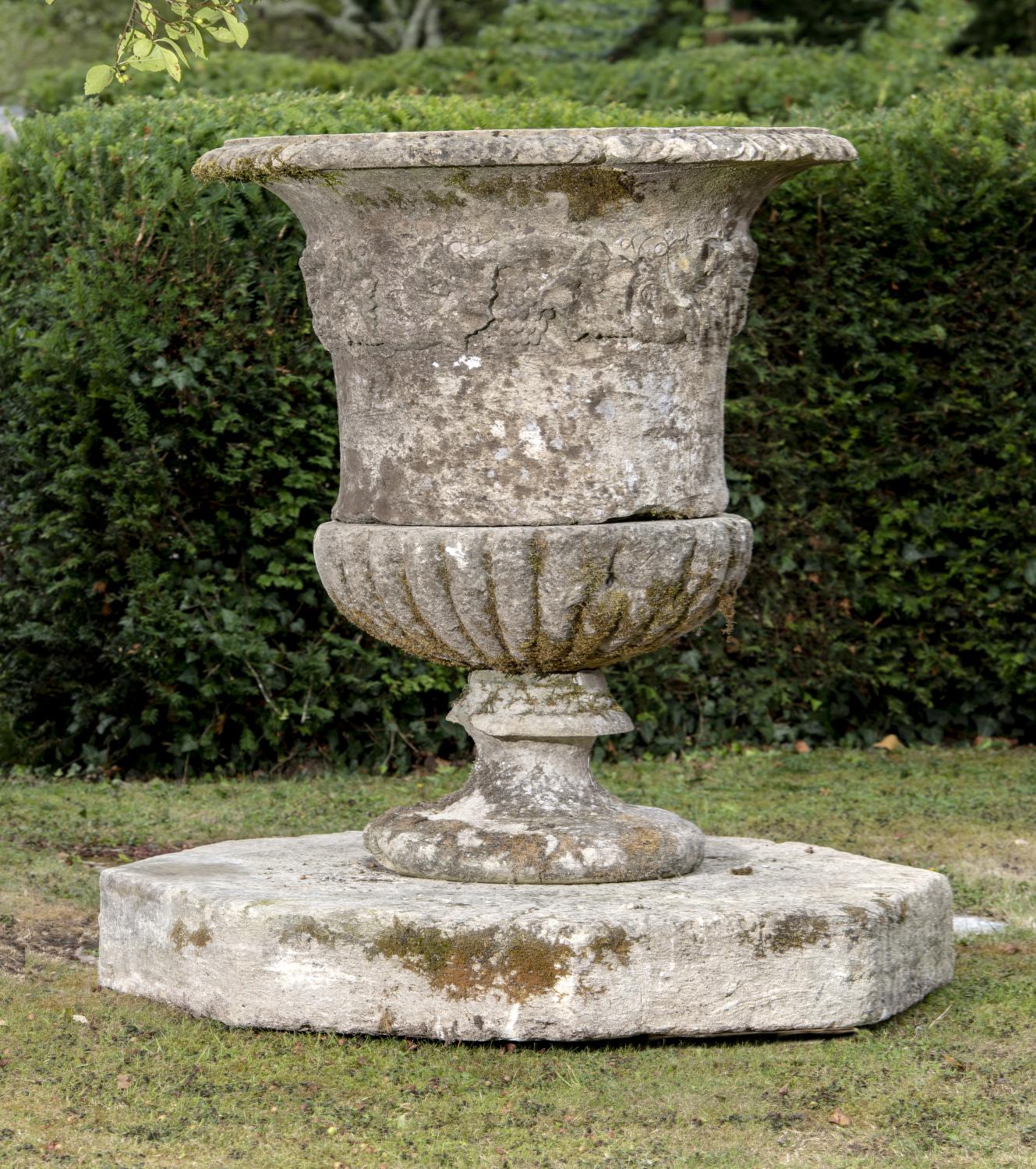 Garden pots/planters: A substantial carved Cotswold stone urn, 18th century, on associated octagonal